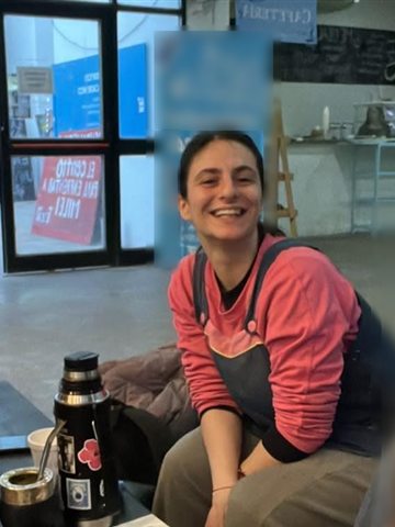 Valentina, sonriendo, con el mate en la mesa